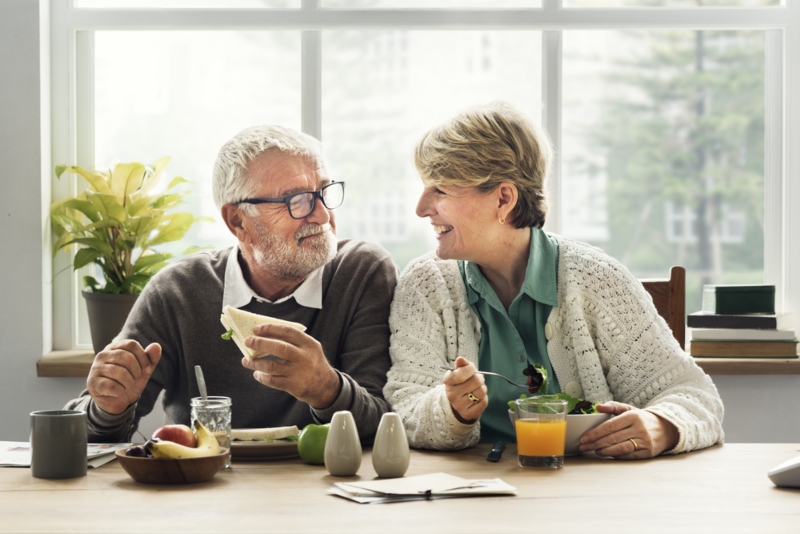 Coppia di over 50 che fanno colazione seduti ad un tavolo in cucina